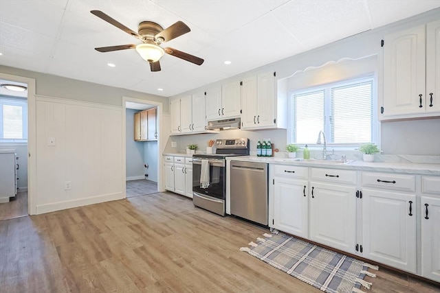 kitchen with sink, plenty of natural light, stainless steel appliances, and white cabinets