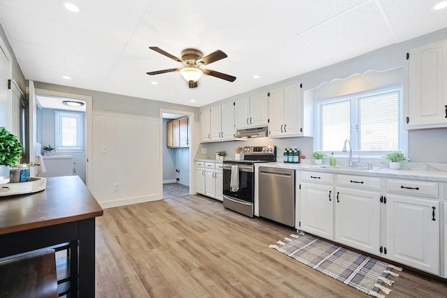 kitchen featuring stainless steel appliances, plenty of natural light, sink, and white cabinets