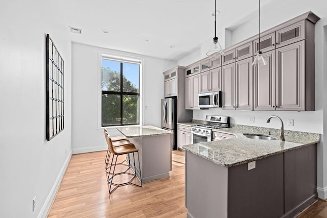 203 Middle St Unit 6, Weymouth, MA 02189 - kitchen with stainless steel appliances, a sink, a breakfast bar area, light wood finished floors, and a center island