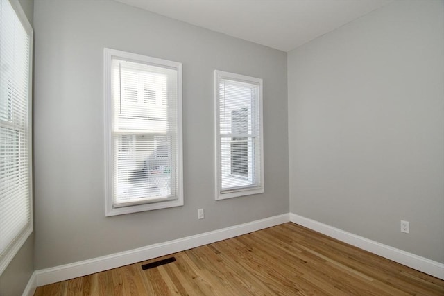 unfurnished room featuring plenty of natural light and hardwood / wood-style floors