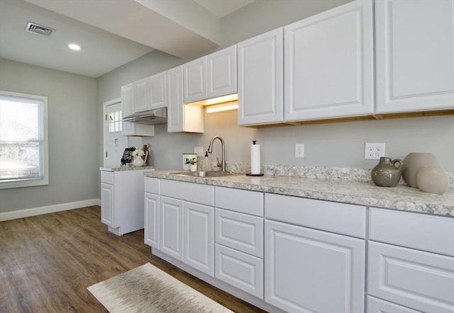 kitchen featuring dark wood-type flooring, sink, and white cabinets