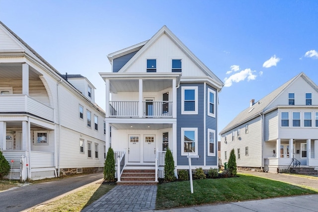 view of front of home featuring a balcony and a front lawn