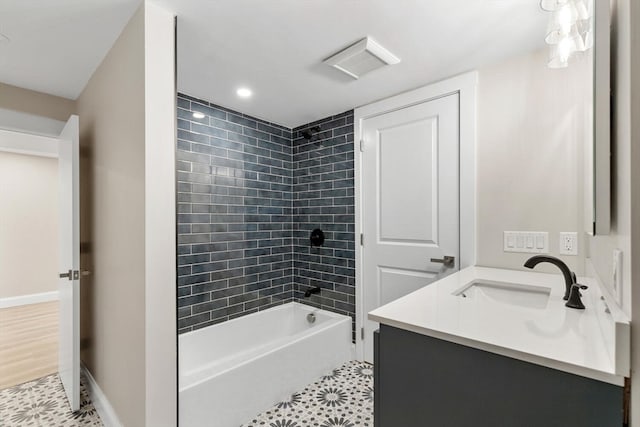 bathroom featuring tile patterned flooring, vanity, and tiled shower / bath