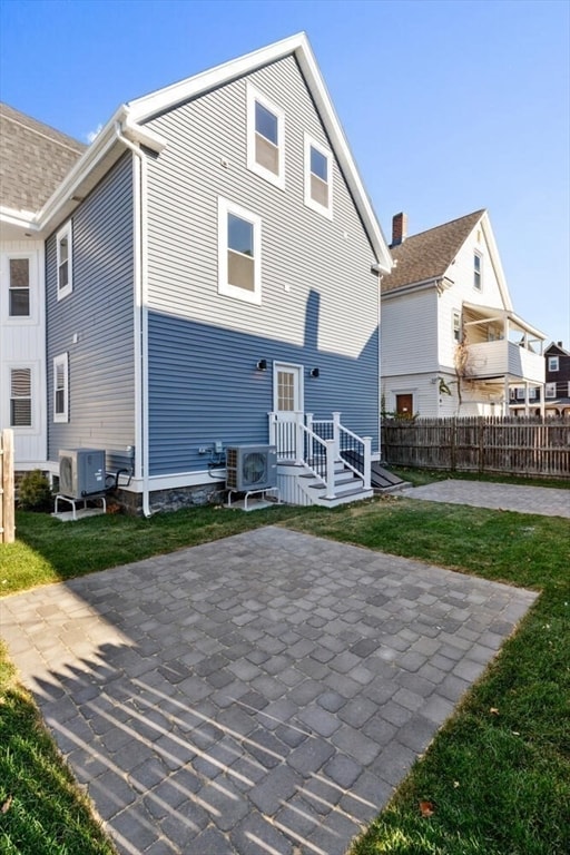 back of property featuring a lawn, central AC unit, and a patio area