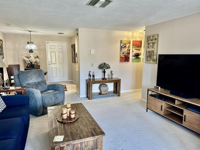 living area featuring visible vents, light carpet, baseboards, and a textured ceiling