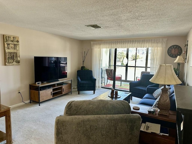 living area with light colored carpet, visible vents, baseboards, and a textured ceiling