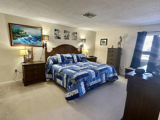 bedroom with baseboards, visible vents, light carpet, and a textured ceiling