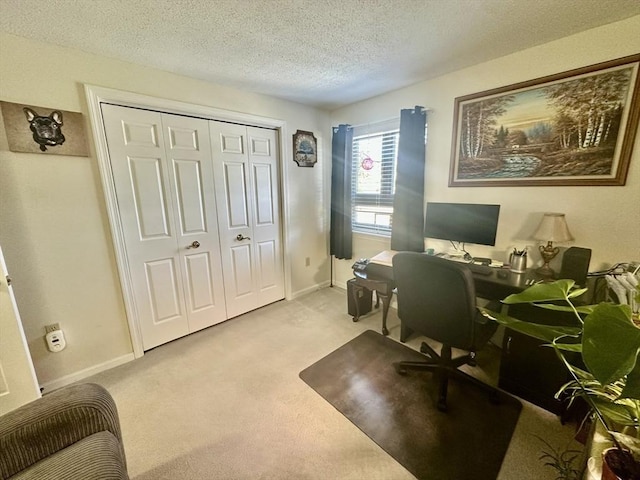 office area with light carpet, a textured ceiling, and baseboards