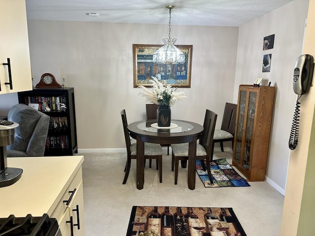 dining space with light carpet, a notable chandelier, and baseboards