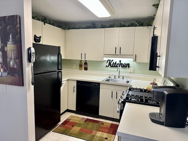 kitchen featuring white cabinets, light countertops, a textured ceiling, black appliances, and a sink