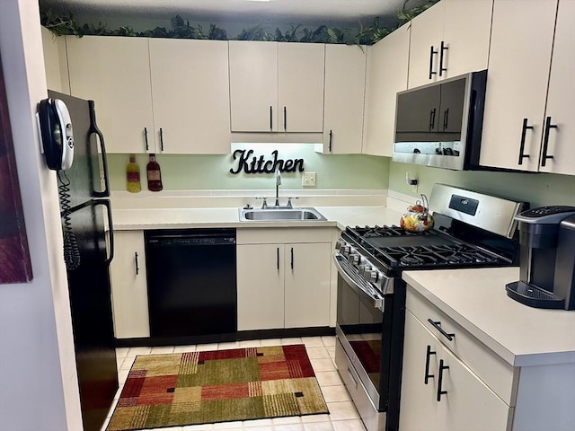 kitchen with light tile patterned floors, white cabinets, light countertops, black appliances, and a sink