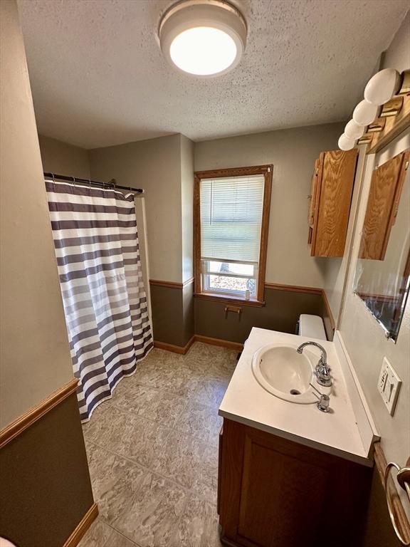 bathroom with vanity, a shower with curtain, tile patterned floors, and a textured ceiling