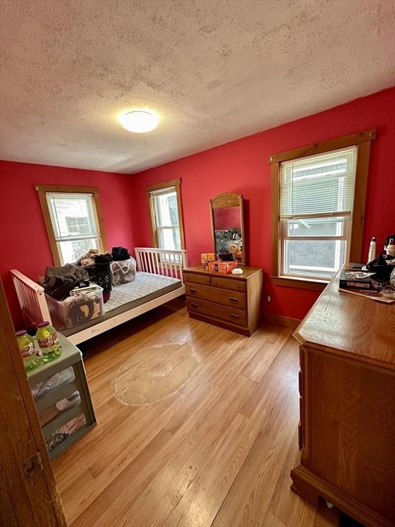 bedroom featuring a textured ceiling and light wood-style flooring