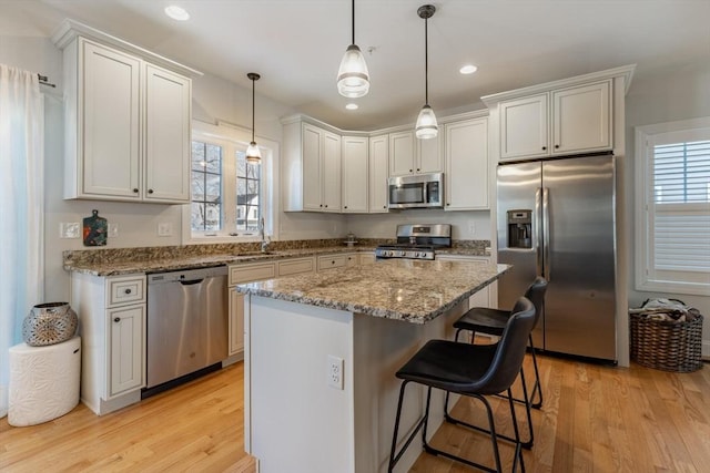 kitchen with stainless steel appliances, white cabinetry, and a kitchen island