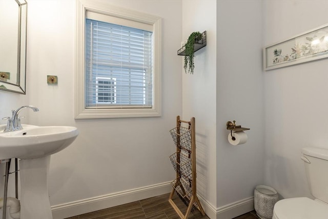 bathroom featuring hardwood / wood-style flooring, toilet, and sink