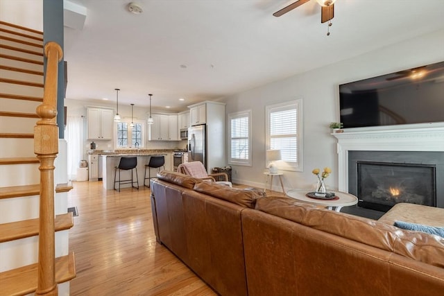 living room featuring ceiling fan and light hardwood / wood-style flooring