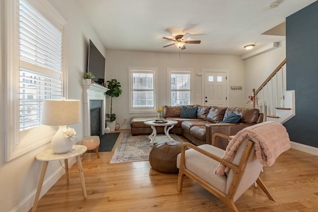 living room with plenty of natural light, ceiling fan, and light wood-type flooring