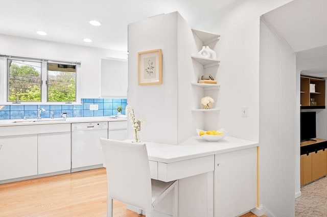 kitchen featuring white dishwasher, light countertops, open shelves, and a sink