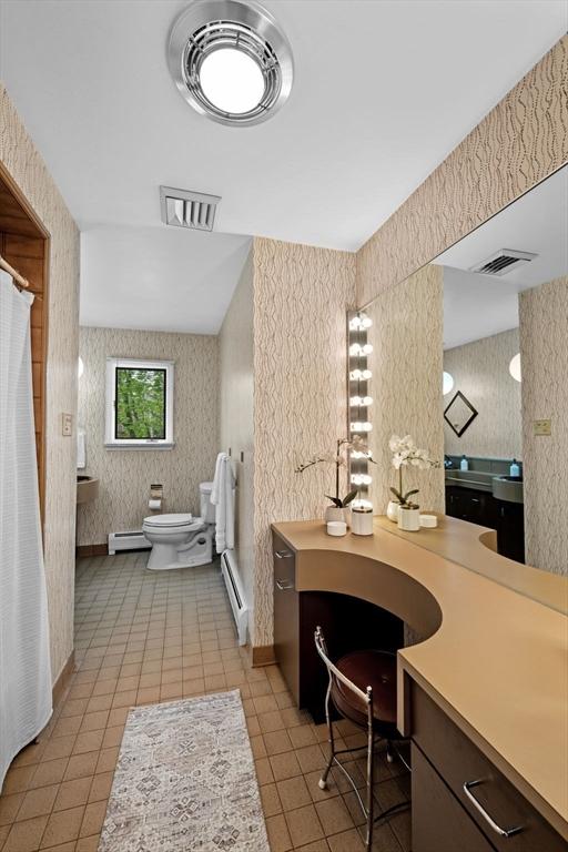full bath with wallpapered walls, toilet, and baseboard heating