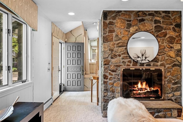 interior space featuring a wealth of natural light, a baseboard radiator, and a fireplace