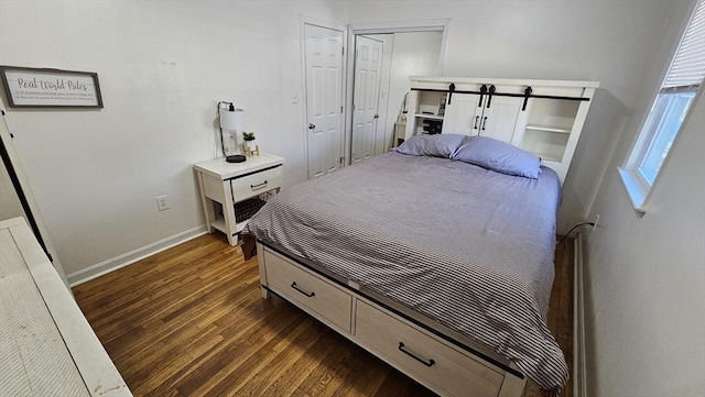 bedroom featuring dark wood-type flooring and baseboards