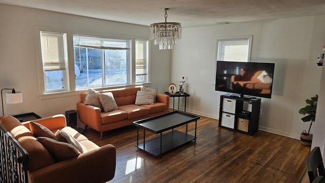 living area featuring an inviting chandelier, baseboards, and wood finished floors