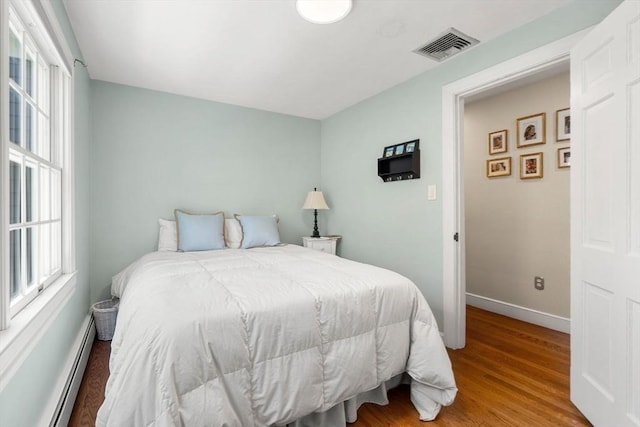 4 Crestwood, Marblehead, MA 01945 - bedroom featuring a baseboard heating unit, multiple windows, baseboards, and wood finished floors