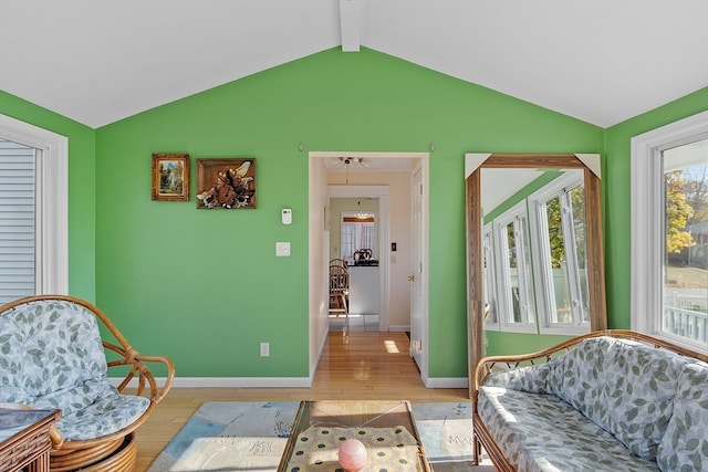 sitting room with light hardwood / wood-style flooring and vaulted ceiling with beams