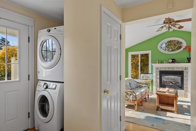 laundry area with hardwood / wood-style floors, stacked washer and clothes dryer, and ceiling fan