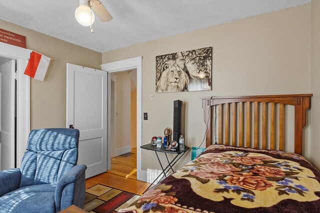 bedroom featuring a textured ceiling, ceiling fan, and light hardwood / wood-style flooring