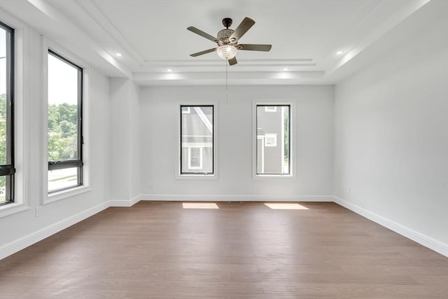 spare room featuring hardwood / wood-style floors, ceiling fan, and a tray ceiling