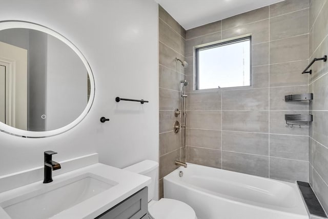 full bathroom featuring tiled shower / bath, vanity, and toilet