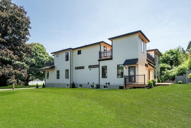 rear view of property featuring a balcony, a yard, and central AC