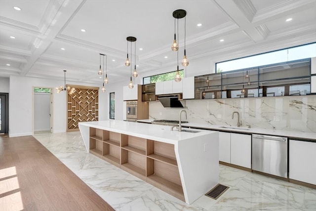 kitchen with white cabinetry, sink, stainless steel appliances, an island with sink, and pendant lighting