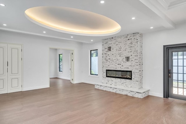 unfurnished living room with a wealth of natural light, a fireplace, and light hardwood / wood-style flooring