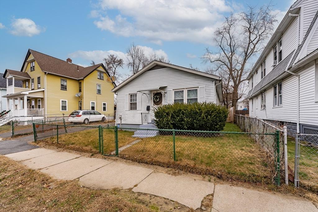 view of front of property with a fenced front yard, a residential view, a gate, and a front lawn