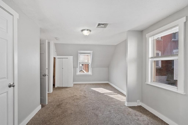 bonus room with vaulted ceiling, baseboards, visible vents, and carpet floors