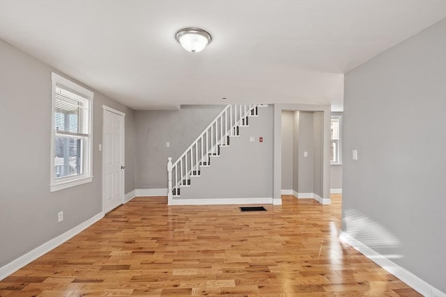 entryway with stairway, plenty of natural light, light wood-type flooring, and visible vents