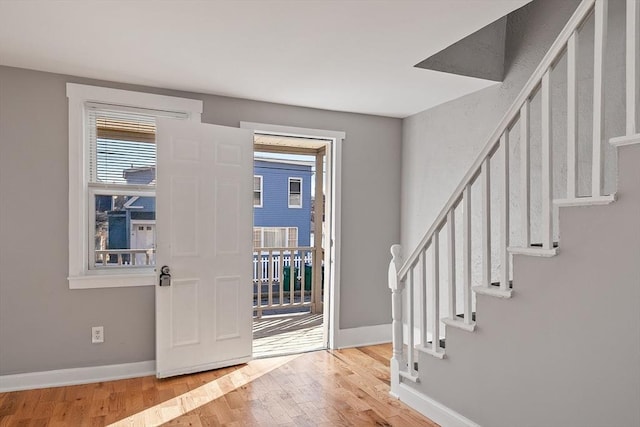 foyer with stairway, baseboards, and wood finished floors