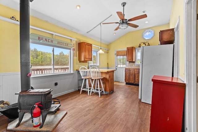 49 Boathouse Rd, Groton, MA 01450 - kitchen with freestanding refrigerator, a wood stove, ceiling fan, a peninsula, and vaulted ceiling
