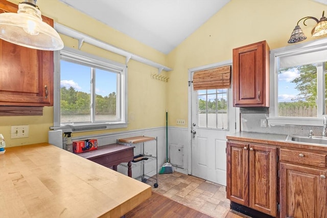 49 Boathouse Rd, Groton, MA 01450 - kitchen with a sink, vaulted ceiling, light countertops, wainscoting, and light stone finish floors
