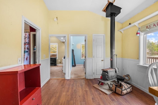 49 Boathouse Rd, Groton, MA 01450 - interior space with a wood stove, multiple windows, wood finished floors, lofted ceiling, and a wainscoted wall