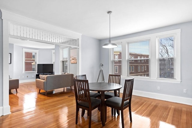 dining area featuring baseboards, healthy amount of natural light, and light wood finished floors