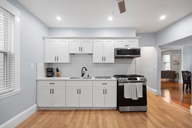 kitchen with white cabinetry, appliances with stainless steel finishes, and light hardwood / wood-style flooring