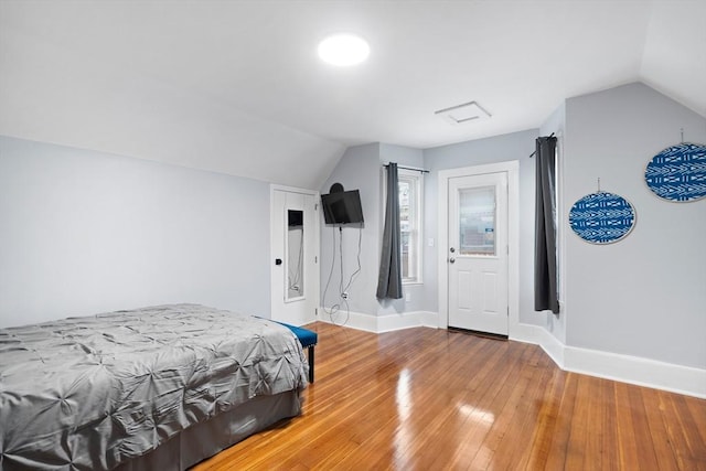 bedroom featuring vaulted ceiling, wood-type flooring, and baseboards