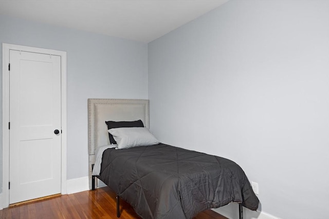 bedroom featuring wood finished floors and baseboards