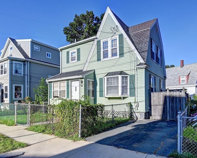 view of front of property with a fenced front yard and roof with shingles