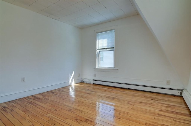 interior space with a baseboard heating unit and light wood finished floors