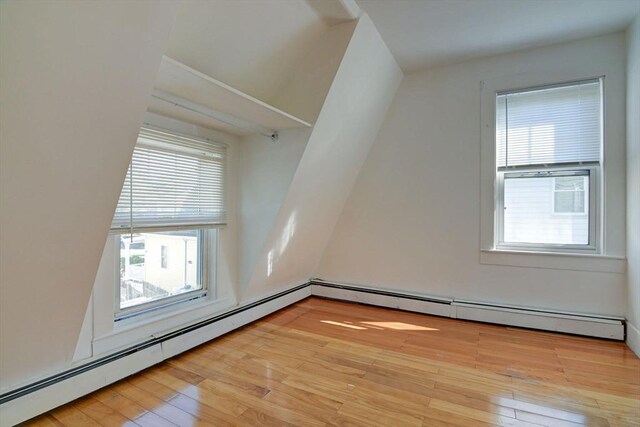 bonus room with a wealth of natural light, light wood-style flooring, and a baseboard radiator
