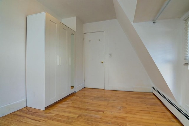 bonus room with baseboard heating and light wood-style floors